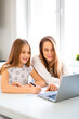 © Stavros - Online education concept. Mom helps her daughter do her homework online. They looking to laptop monitor.