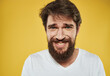 © SHOTPRIME STUDIO - Emotional man with thick beard grinning model yellow background