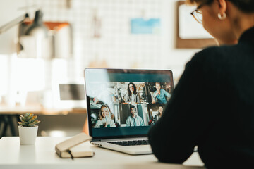 Wall Mural - Woman has video call with her team using laptop and camera