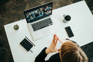 Wall Mural - Woman has video conference with her remote team using laptop. Top view