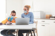 © astrosystem - Child home studying education, homeschooling, with private tutor / mother with protective mask in the time of viruses, flu and seasonal pandemic.