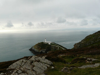 White lighthouse and calm sea under the cloudy sky in Wales