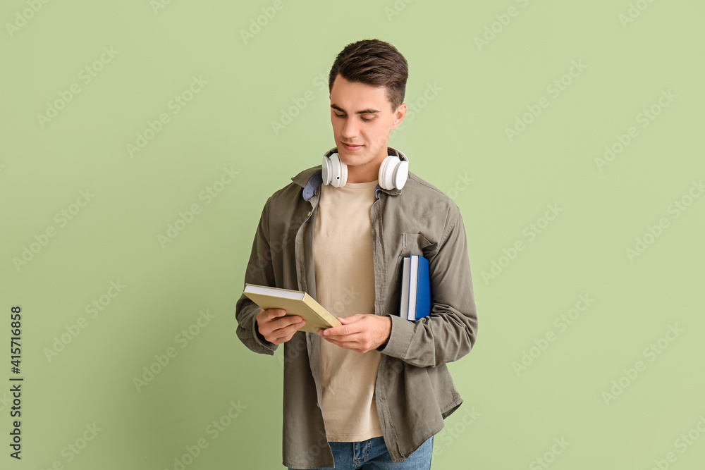 Young man with books on color background