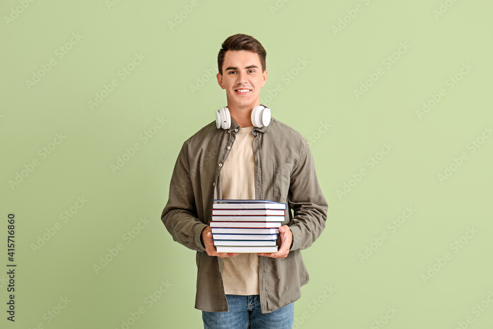Young man with books on color background