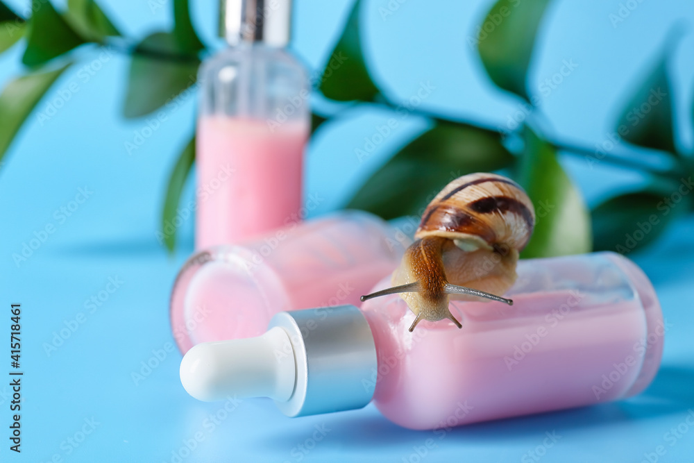 Cosmetics with mucin and snail on color background