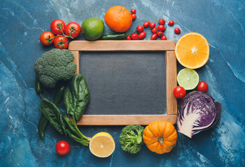 Empty chalkboard and healthy products on dark color background