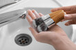 © Pixel-Shot - Woman washing makeup brushes under water