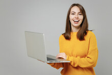 Young Smiling Happy Freelancer Copywriter Positive Cute Attractive Caucasian Woman 20s Wear Casual Knitted Yellow Sweater Hold Laptop Pc Computer Isolated On Grey Color Background Studio Portrait