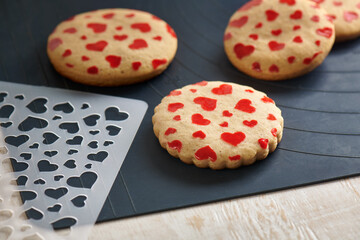 Wall Mural - Cookies with a pattern in the form of hearts, stencil on a baking mat