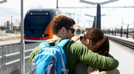 Sticker - travel, tourism and people concept - happy young couple with backpacks traveling over train on railway station on background