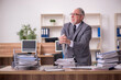 © Elnur - Old male employee unhappy with excessive work in the office