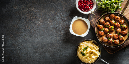 Obraz Dibond Top view of Swedish meatballs kottbullar with bowls of sauce, potato mash and cranberries on the side