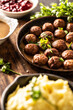 Swedish food Kottbullar meatballs, served in a pan with mashed potatoes, parsley and cranberry sauce