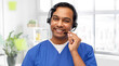 © Syda Productions - medicine, profession and healthcare concept - happy smiling indian doctor or male nurse with headset over medical office at hospital background