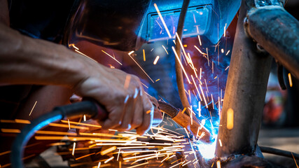 Wall Mural - Welding of steel, sparking, not wearing gloves, light colored like fireworks.