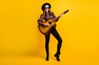 © deagreez - Full length body size photo of happy brunette playing acoustic guitar overjoyed isolated vibrant yellow color background