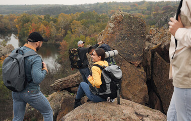 Wall Mural - Group of hikers with backpacks climbing down mountain