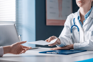 Doctor giving a prescription to a patient