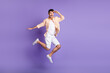 Full size profile photo of hooray brunet guy jump look wear peach shirt shorts sneakers isolated on lilac background
