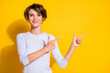 Photo of lady indicate forefingers empty space look camera wear white shirt isolated yellow color background