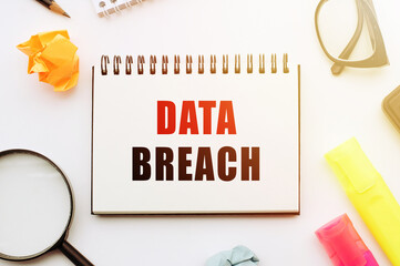 data breach. text in notebook on white table with office tools.