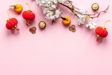 Flat lay of Chinese new year table set with oranges, golden sweets and flowers