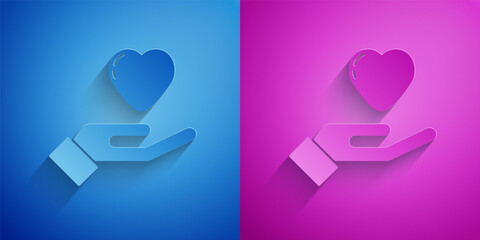 Poster - Paper cut Heart in hand icon isolated on blue and purple background. Hand giving love symbol. Valentines day symbol. Paper art style. Vector.