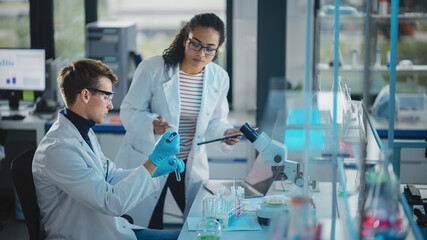 Wall Mural - modern medical research laboratory: portrait of two young scientists using pipette, digital tablet, 