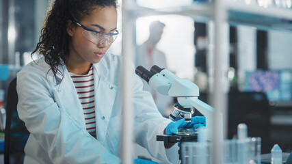 Wall Mural - medical science laboratory: portrait of beautiful black scientist using microscope, does analysis of