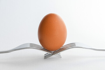 egg on two forks against white