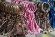 Colorful close up assortment of miniature Eiffel Tower key chains in pink, brown, gold and blue hanging on a rack