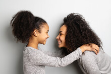 African American Mother With Her Daughter Looking And Smiling At Each Other.