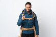 © luismolinero - Young mountaineer man with a big backpack isolated on white background points finger at you
