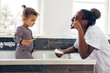 © Flamingo Images - Mom showing her smiling little daughter how to brush her teeth