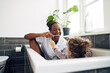 © Flamingo Images - Smiling mom teaching her little girl how to brush her teeth