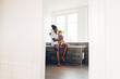 © Flamingo Images - Young mom and little girl sitting in their bathroom at home