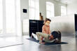 © Flamingo Images - Mom and her little girl doing yoga together at home
