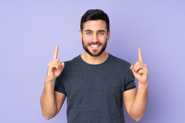 Sticker - Caucasian handsome man pointing up a great idea over isolated purple background