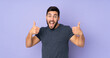 © luismolinero - Caucasian handsome man giving a thumbs up gesture over isolated purple background