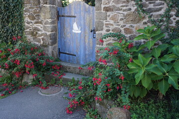 Wall Mural - blue painted door with white sailboat going in the garden