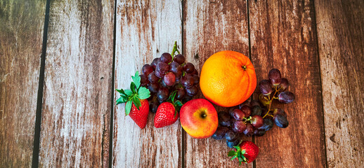 Wall Mural - Fresh fruit that lies decoratively in the sunlight on a wooden table.