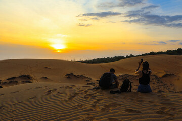 A couple watching a colorful sunset on la dune du Pyla, France