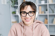© Oleksandr - Portrait of smiling young woman in headphones looking into the camera. The face of a happy female student studying online.