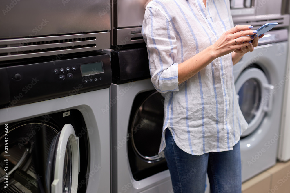 Enjoying of easy laundry process. cropped photo of young lady standing ...