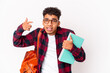 © Asier - Young african american student curly man isolated holding books showing a disappointment gesture with forefinger.
