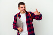 © Asier - Young caucasian student man holding a laptop isolated on white background person pointing by hand to a shirt copy space, proud and confident