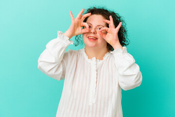 Woman with Down syndrome isolated showing okay sign over eyes