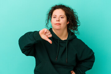 Woman with Down syndrome isolated showing thumb down, disappointment concept.