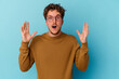 © Asier - Young caucasian man wearing eyeglasses isolated on blue background celebrating a victory or success, he is surprised and shocked.