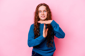 Wall Mural - Little caucasian girl isolated on pink background showing a timeout gesture.